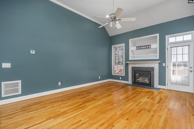 unfurnished living room featuring visible vents, a fireplace with flush hearth, a ceiling fan, wood finished floors, and baseboards