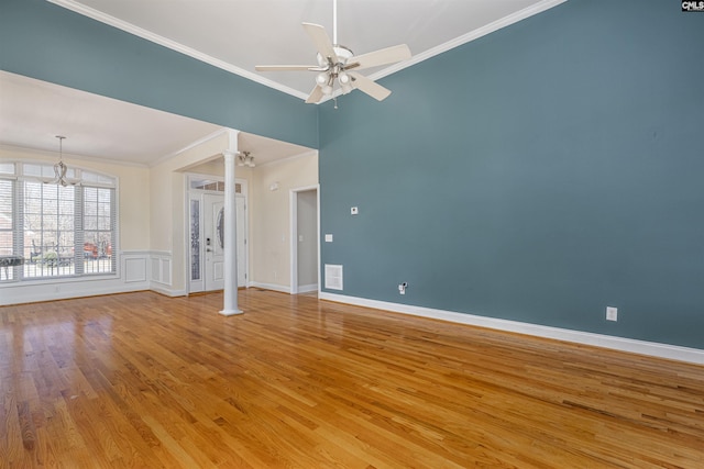 unfurnished room featuring decorative columns, crown molding, light wood finished floors, baseboards, and ceiling fan with notable chandelier