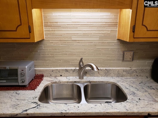 910 Poinsett Pl Unit 5, West Columbia, SC 29169 - room details with a toaster, a wood stove, light stone countertops, a sink, and backsplash