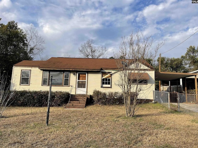 view of front facade featuring a front yard, a gate, fence, an attached carport, and driveway