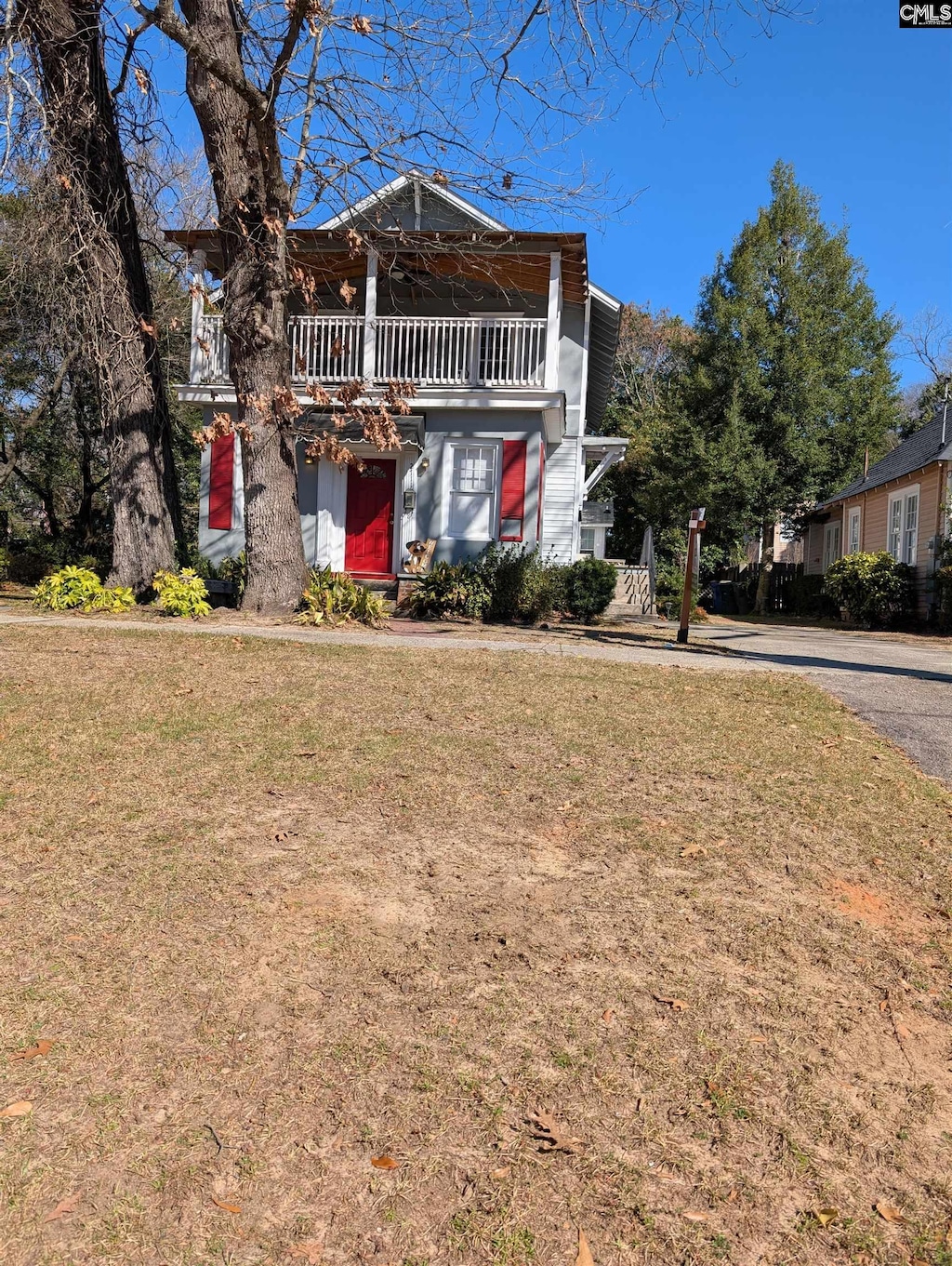 view of front facade featuring a front lawn and a balcony