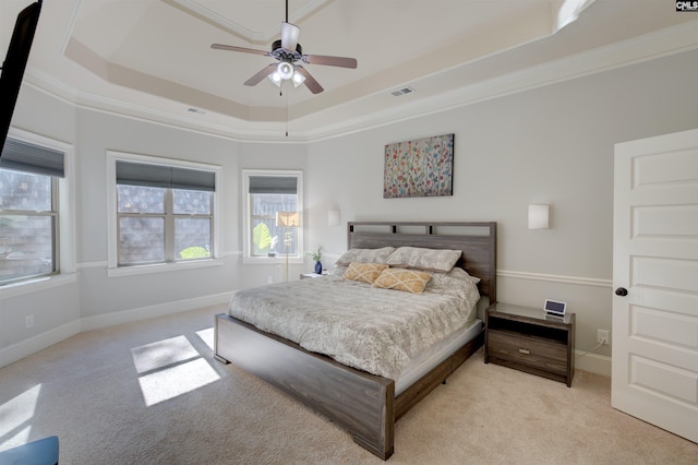 bedroom with baseboards, a tray ceiling, and light colored carpet