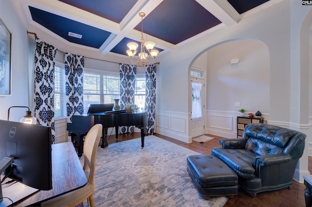 office space with arched walkways, wood finished floors, beam ceiling, and an inviting chandelier