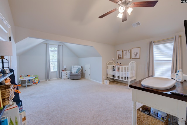 carpeted bedroom featuring lofted ceiling, a ceiling fan, visible vents, and baseboards