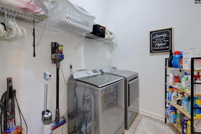 laundry room featuring laundry area, washing machine and clothes dryer, and baseboards