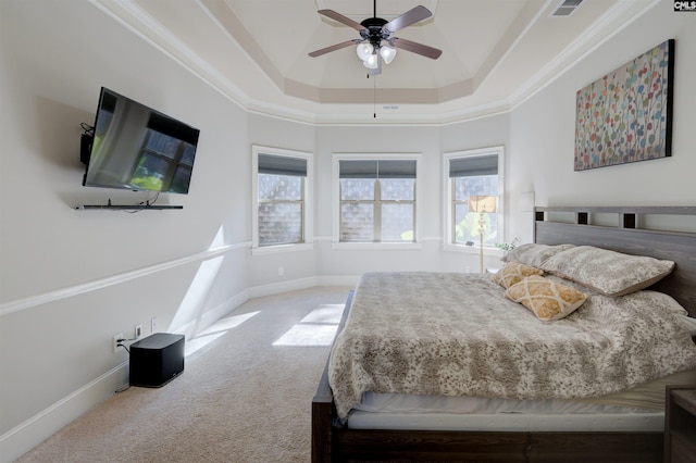 carpeted bedroom with multiple windows, baseboards, a raised ceiling, and a ceiling fan