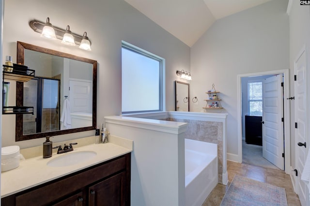 full bathroom featuring lofted ceiling, a stall shower, a garden tub, and vanity