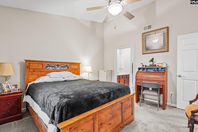 bedroom with connected bathroom, light colored carpet, a ceiling fan, baseboards, and visible vents