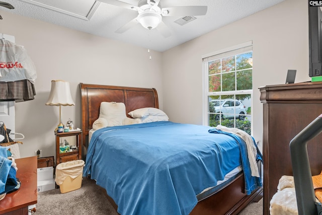 bedroom with ceiling fan, a textured ceiling, carpet, and visible vents