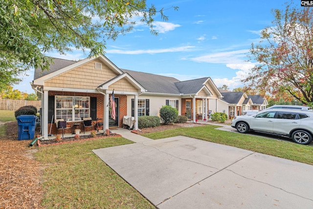 view of front of home with a front yard, brick siding, and fence