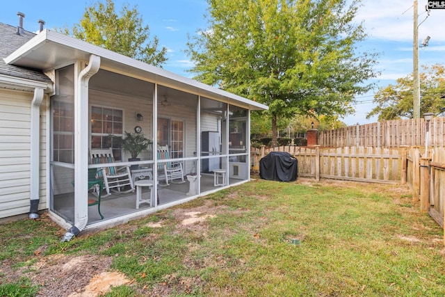 view of yard with a sunroom and a fenced backyard