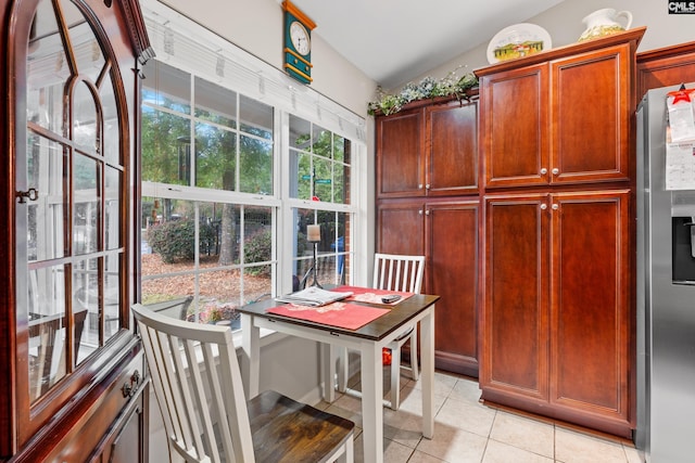 dining area with vaulted ceiling and light tile patterned floors