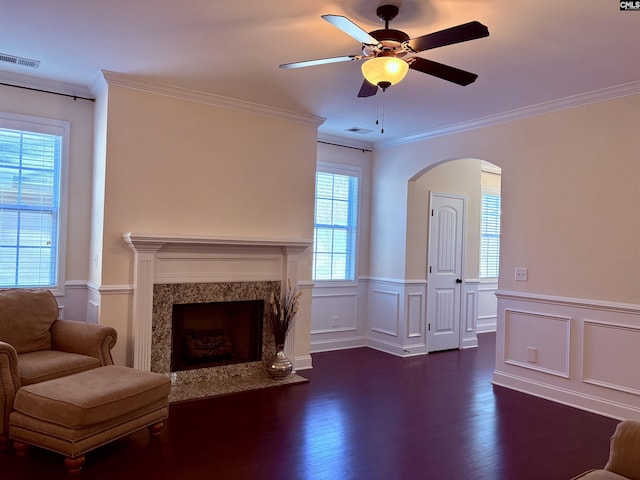 unfurnished living room featuring dark wood-style floors, a premium fireplace, visible vents, and crown molding