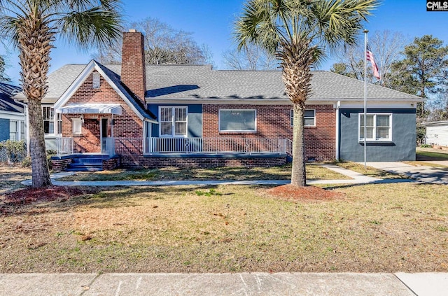 view of front of home with brick siding, a chimney, a front lawn, and roof with shingles