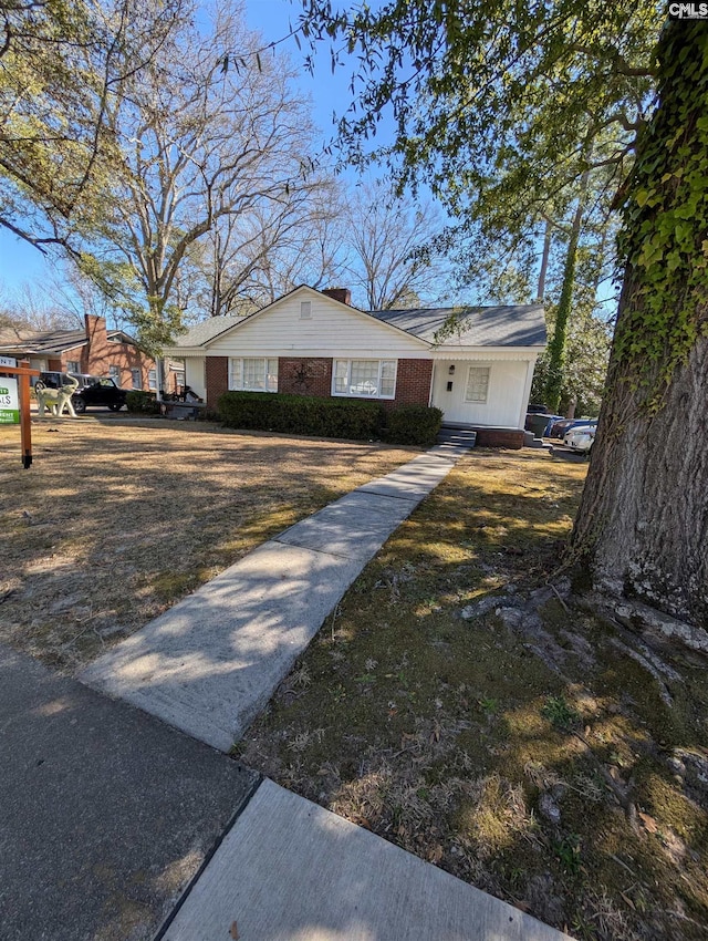 view of front of home with brick siding and a front yard