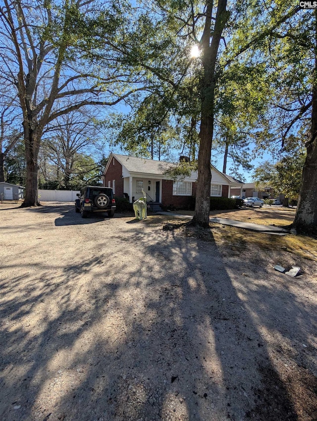 view of front of property featuring fence and brick siding