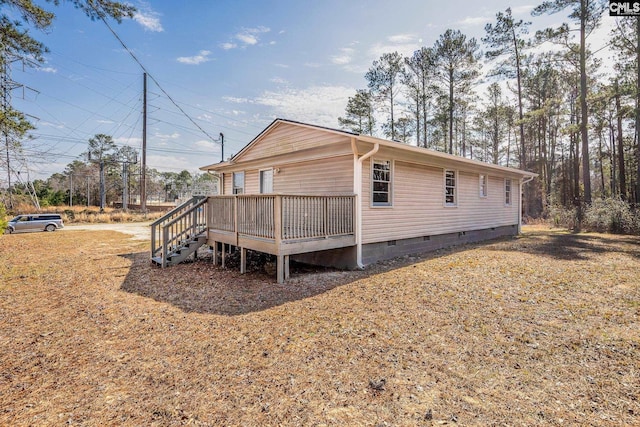 view of side of property with crawl space and a wooden deck