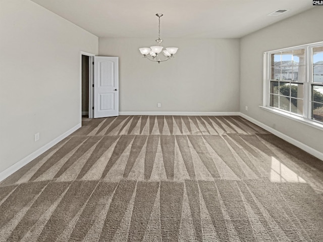 unfurnished room featuring a notable chandelier, carpet, visible vents, and baseboards