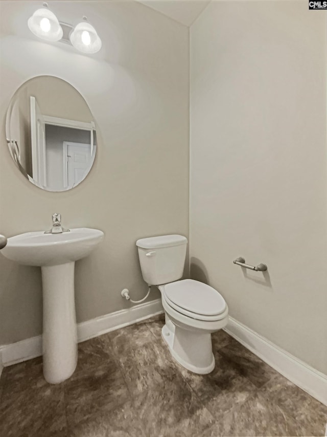 bathroom with toilet and baseboards