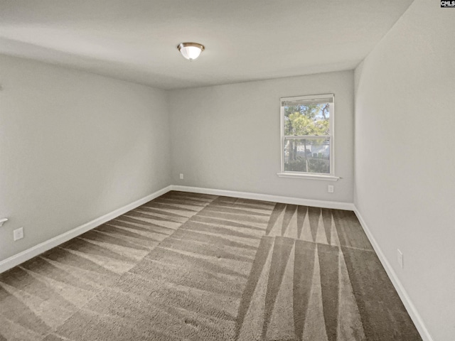 empty room featuring carpet floors and baseboards