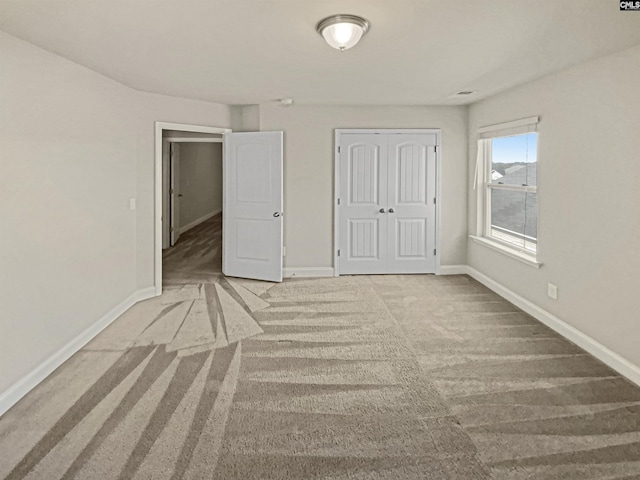 unfurnished bedroom with a closet, baseboards, and carpet flooring