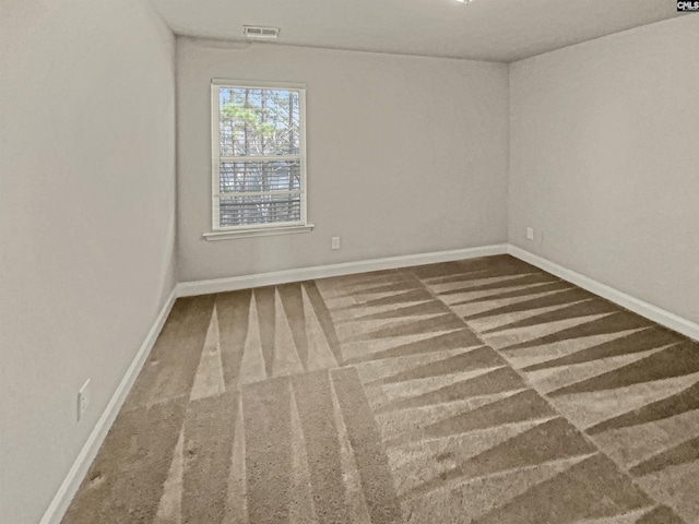 carpeted empty room with visible vents and baseboards