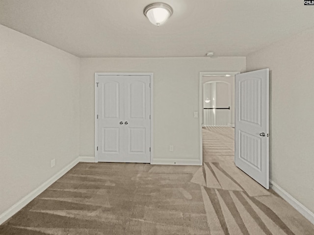 unfurnished bedroom featuring carpet floors and baseboards