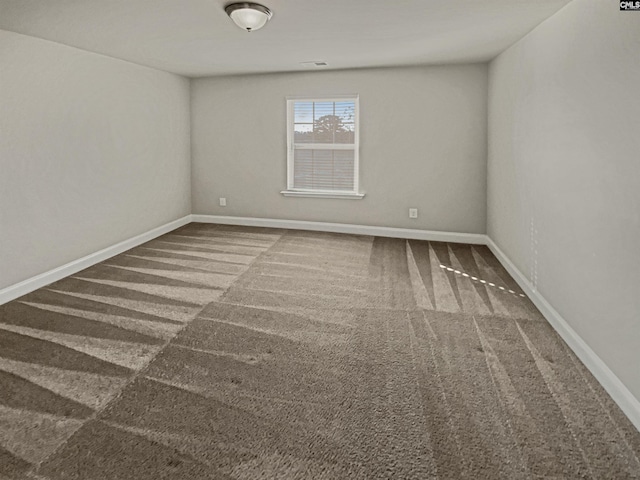 carpeted spare room featuring baseboards