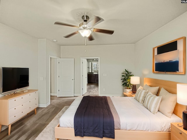 bedroom featuring a ceiling fan, baseboards, wood finished floors, and ensuite bathroom