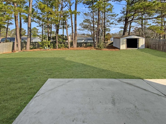 view of yard featuring a fenced backyard, a storage unit, and an outbuilding