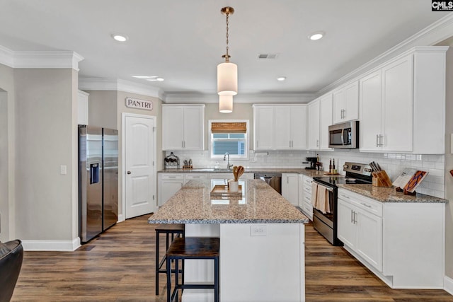 kitchen with stainless steel appliances, a center island, dark wood finished floors, and a kitchen bar