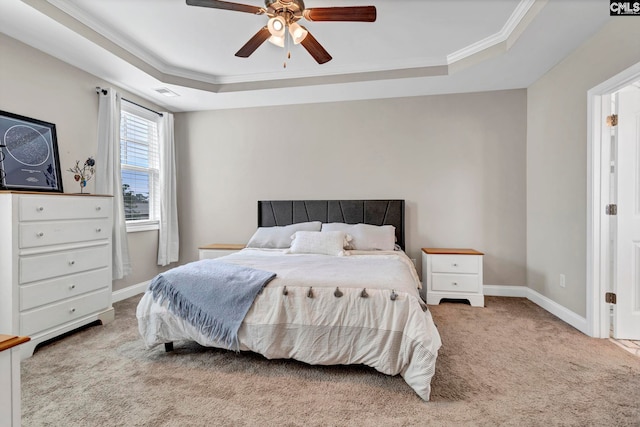 carpeted bedroom featuring baseboards, visible vents, a tray ceiling, and ornamental molding