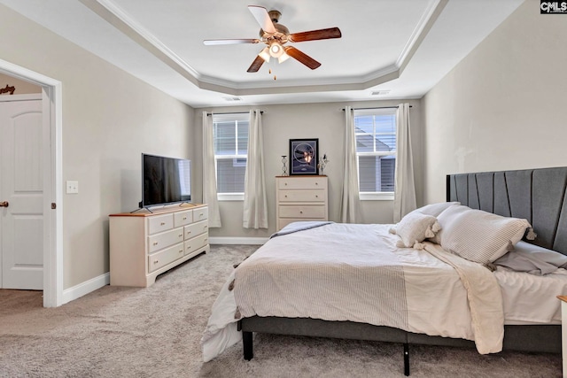 bedroom featuring visible vents, a raised ceiling, crown molding, and light colored carpet