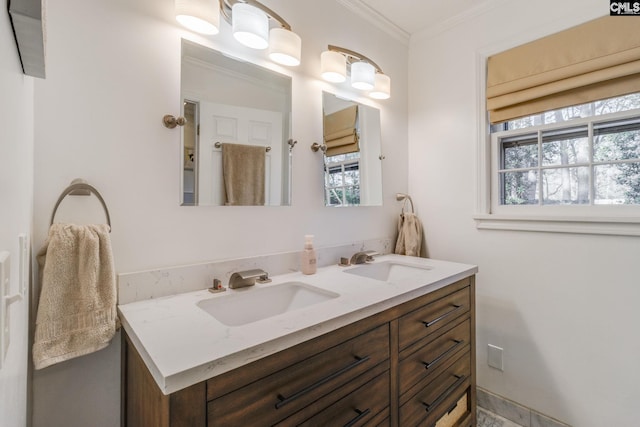 full bath featuring double vanity, a sink, and crown molding