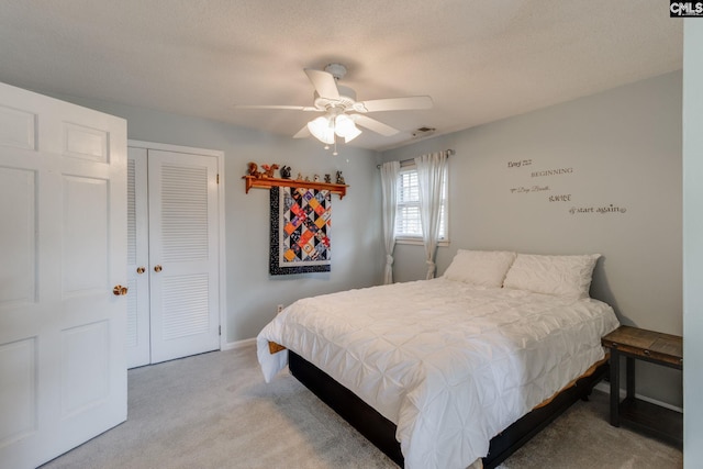 bedroom with a closet, visible vents, a ceiling fan, carpet flooring, and baseboards