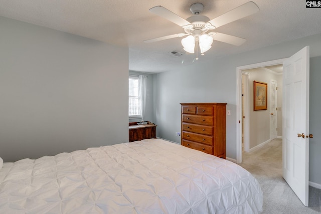 bedroom featuring visible vents, light carpet, ceiling fan, a textured ceiling, and baseboards