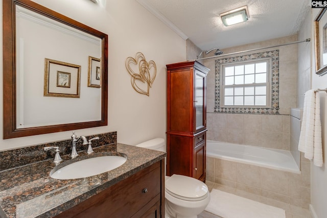 full bathroom with a textured ceiling, toilet, vanity, tiled shower / bath, and crown molding