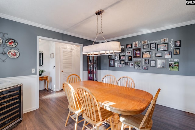 dining room featuring crown molding, wine cooler, baseboards, and wood finished floors