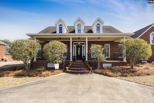 view of front facade featuring covered porch, brick siding, crawl space, and a shingled roof