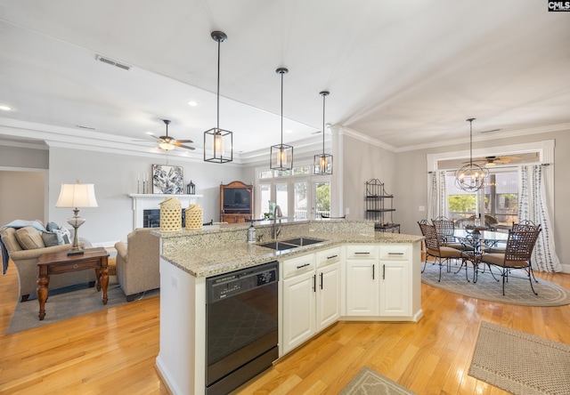 kitchen featuring a fireplace, light wood-style flooring, open floor plan, a sink, and dishwasher