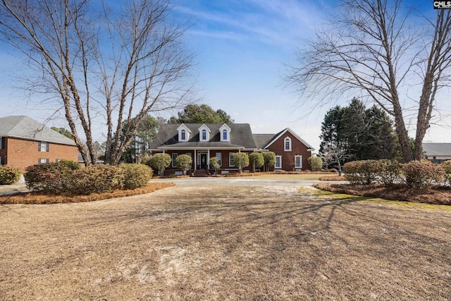 cape cod house featuring driveway