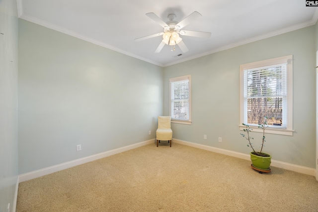 unfurnished room with carpet floors, a ceiling fan, baseboards, and crown molding