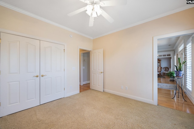 unfurnished bedroom featuring baseboards, a closet, carpet, and crown molding