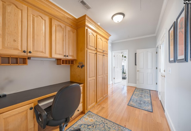 office with baseboards, visible vents, built in study area, light wood-style flooring, and crown molding