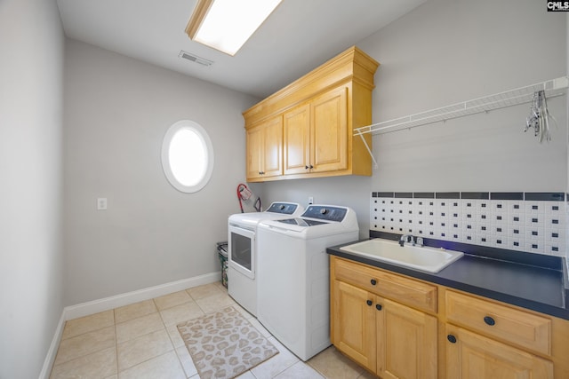 laundry area with cabinet space, light tile patterned floors, visible vents, washer and dryer, and a sink