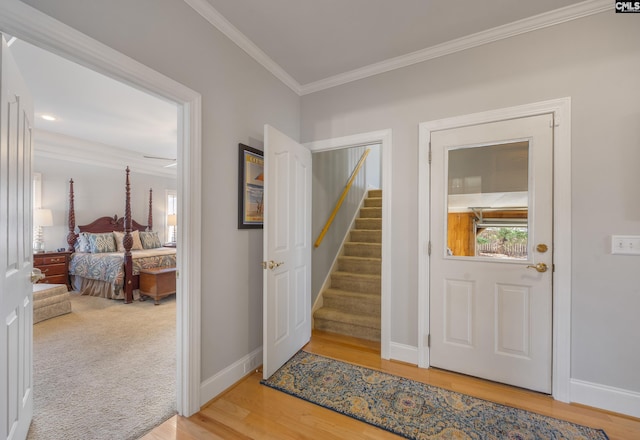 foyer entrance featuring ornamental molding, stairway, and baseboards