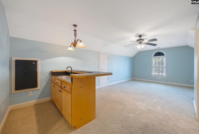 kitchen with light carpet, a peninsula, a sink, baseboards, and vaulted ceiling