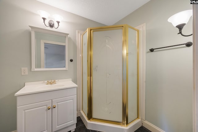 bathroom with a textured ceiling, a stall shower, and vanity