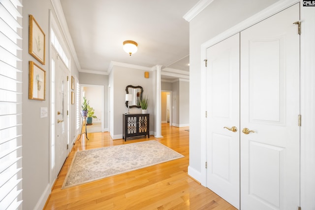 entryway featuring light wood finished floors, baseboards, and ornamental molding