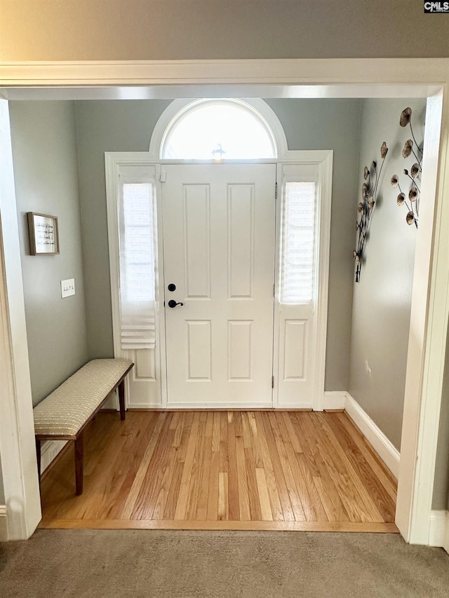 entryway with light wood finished floors and baseboards